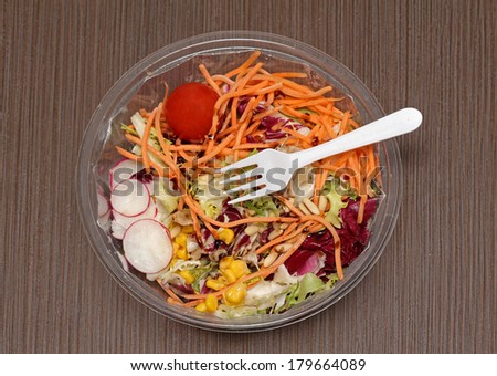 Fresh vegetables salad in takeaway plastic container with fork on top