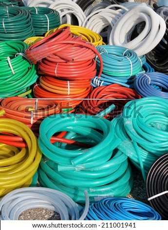 Big pile of colorful plastic garden hoses