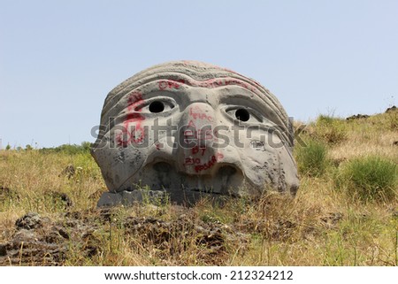 NAPLES, ITALY - June 24; Stone face sculpture on mount Vesuvius in Naples ruined by graffiti in Vesuvius, Italy - June 24, 2014; Ancient sculpture made of stone vandalized by color paint graffiti