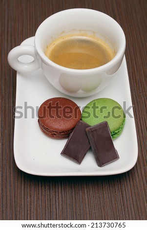Traditional Italian espresso coffee with piece of dark chocolate and macaroons