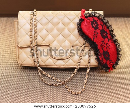 Fashionable leather beige bag with lace sleeping mask in corner