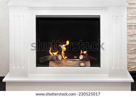 White marble fireplace in modern interior with flame burning