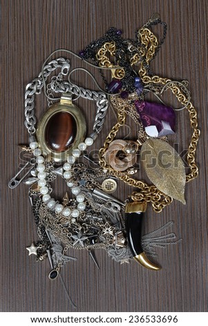 Shiny jewelry pile on brown wooden background