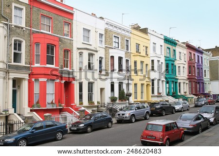 LONDON, UK - April 03: Notting Hill street with colorful houses architecture and parked cars in London, UK - April 03, 2010; Houses with colorful facades in Notting Hill neighborhood