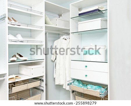 Detail of large walk in closet with wardrobe on hangers