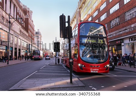 LONDON, UNITED KINGDOM - FEBRUARY 08: London public transport red bus on Oxford Street traffic in London, UK - February 08, 2015; Oxford Street in London with red bus waiting on the traffic light.
