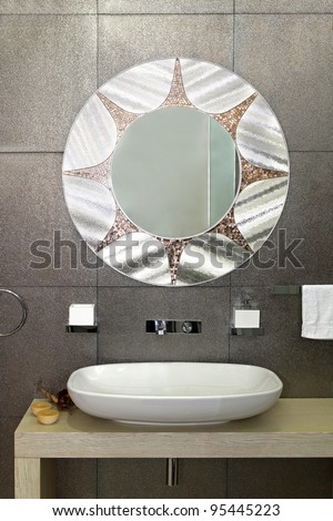 Modern bathroom with sparkling tiles and oval mirror