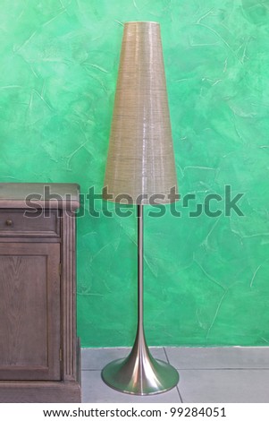 Tall floor lamp in retro interior with green wall