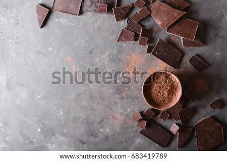 Chocolate  chunks and cocoa powder. Chocolate bar pieces.  Background with chocolate. Slices of chocolate, Sweet food photo concept. Copyspace