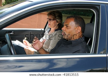 a mature African - American man having a driving test and being stressed out by the tester