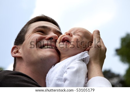 a desperate young father trying to calm down his crying 7 weeks old daughter without success
