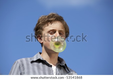 teenager making fun with a chewing gum bubble