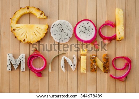letters from fruits on wooden background, the words good morning, photography