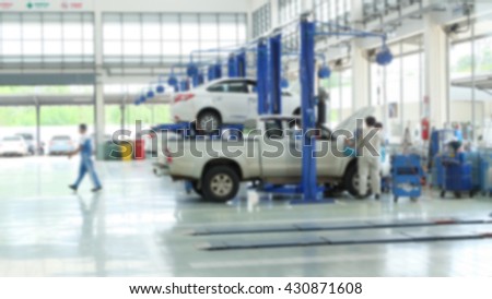 two cars on lifts and on floor in small service station. Cars prepared to diagnosis and repair.