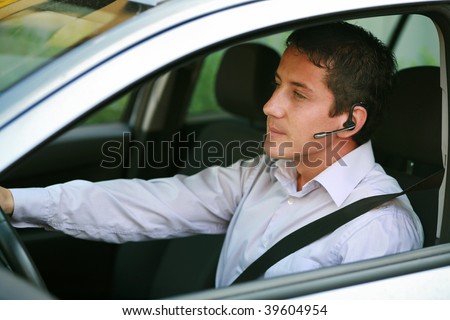 Businessman in car with hands-free blue-tooth
