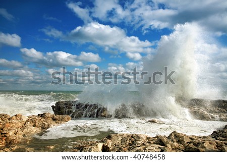 Summer huge waves breaking on rocks in the sea