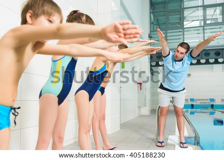 Instructor  and group of children doing exercises near a swimming pool