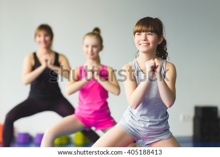 Girls and Instructor or mother doing gymnastic exercises  in fitness class