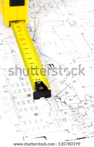 Yellow measuring tape and architectural drawing