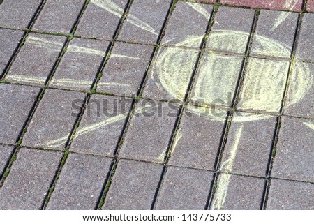 Child\'s drawing of sun on sidewalk