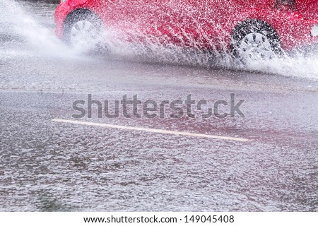 Splash by a car as it goes through flood water