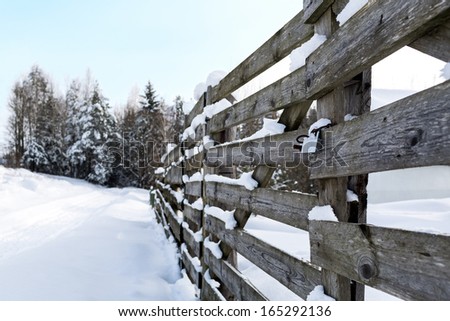Wooden fence in winter snow landscape