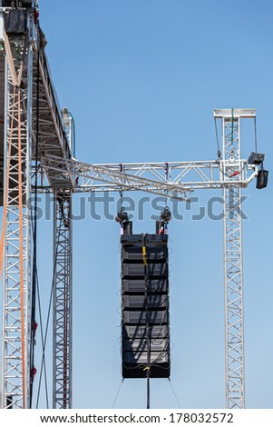 Professional sound equipment high above an outdoor concert
