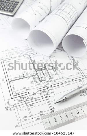 Architectural background with floor plans, rolls of technical drawings and work tools