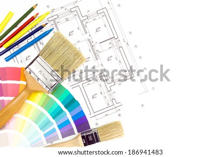 Paintbrushes and colorful paint samples on house plan blueprint background