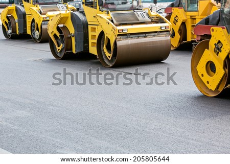 Group of compactors and road rollers at asphalt pavement works
