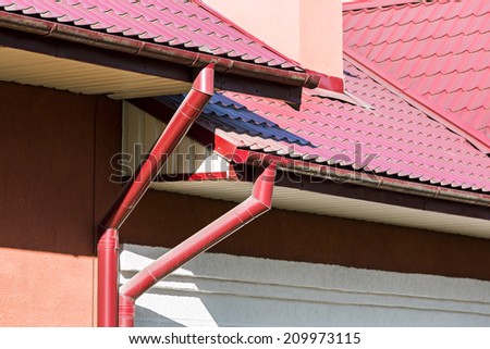 House red tiled roof with rain gutters and drainpipes