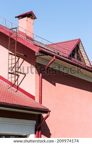 House with rain gutter, drainpipes and red tiled roof
