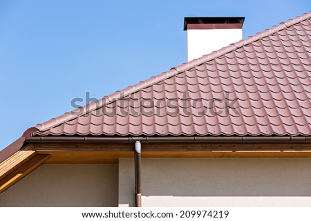 Corner of a house with gutter and tiled roof