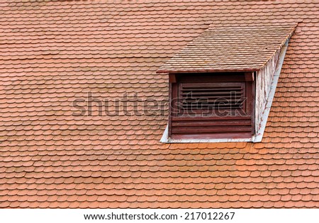 Weathered red tiled roof with dormer window