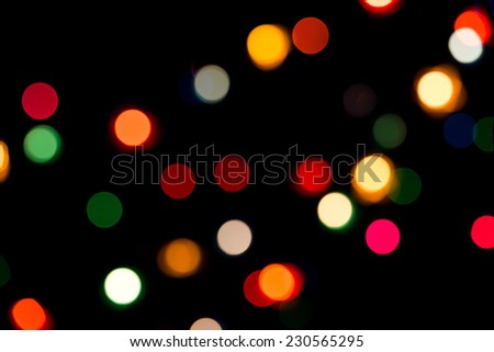 Defocused multicolored light dots against black background