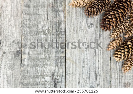 Christmas background with pine cones on weathered wooden boards