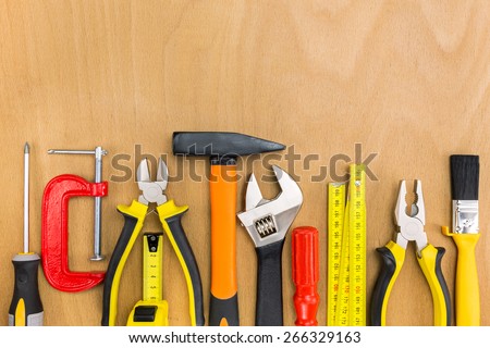 Work tools lined up in a straight line on wooden background