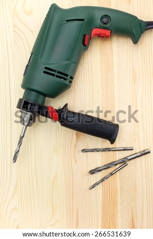 Portable hand electric drill on wooden background