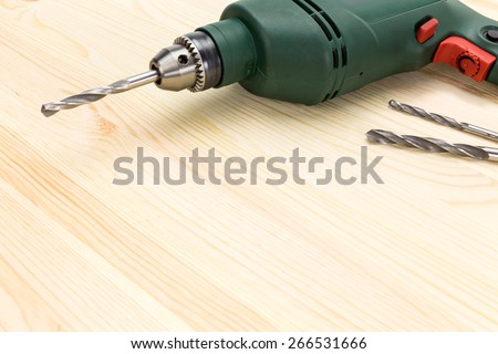 Closeup electric drill driver on wooden background