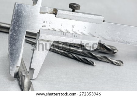 Industrial measurement tool with drill bits on metal background