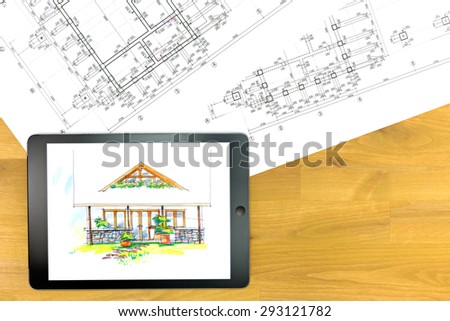 digital tablet with architectural blueprints on wooden table
