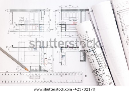 architectural blueprints and blueprint rolls with pencil and ruler