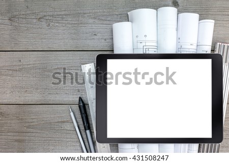 tablet with architectural blueprints and measuring tools on wooden table