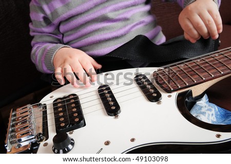 children\'s hands on the electric guitar
