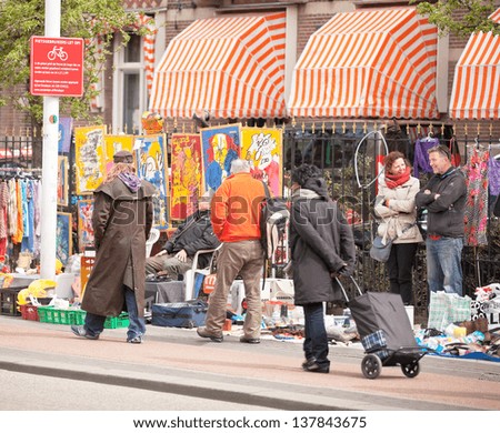 AMSTERDAM -APR 30: Unidentified city natives sell and buy used goods, art at the Free Market held annually on Queen\'s Day, national holiday, in city streets, April 30, 2013, Amsterdam, The Netherlands