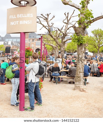AMSTERDAM - JUNE 29: City natives and tourists enjoy free lunch at the city\'s Museum Square at the Damn Food Waste day, food waste prevention initiative, on June 29, 2013, Amsterdam, The Netherlands