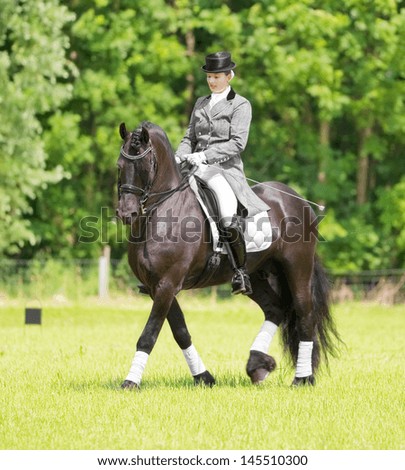 ALMERE - JULY 7: Equestrian Esther Liano demonstrates her horse-riding skills in upper-level dressage during the annual Horse & Outdoor horse show, July 7, 2013 in Almere, The Netherlands