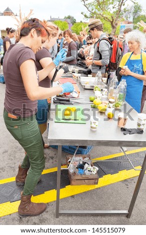 AMSTERDAM - JUNE 29: Volunteers slice saved from wasting away fruit for public consumption on the Damn Food Waste day at the city's Museum Square, June 29, 2013, Amsterdam, The Netherlands
