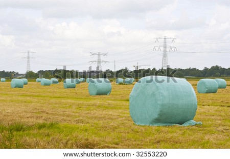 Hay bales wrapped in plastic sitting in the field