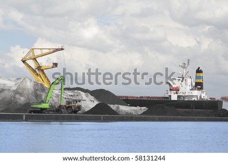 Bulk cargo being loaded onto bulk carrier in port